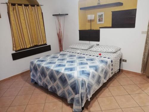 a bedroom with a bed with a blue and white comforter at La casina di Assisi in Assisi