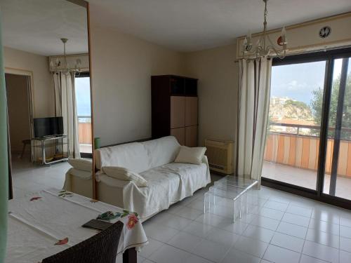 - un salon avec un canapé et une grande fenêtre dans l'établissement Le san marco frontière Monaco, à Saint-Antoine