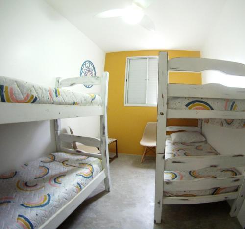 a room with two bunk beds and a window at Apartamento Dona Frida Prainha com WiFi pé na areia in Caraguatatuba