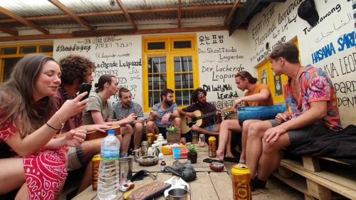 a group of people sitting around a table in a room at Laughing Leopard Hostel in Nuwara Eliya