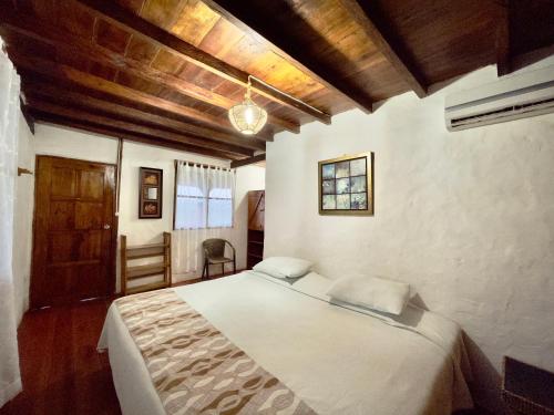 a bedroom with a bed and a wooden ceiling at Samai Lodge Holistic Living in Olón