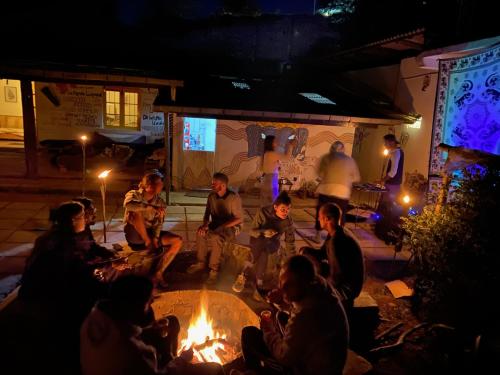a group of people sitting around a fire pit at night at Laughing Leopard Hostel in Nuwara Eliya