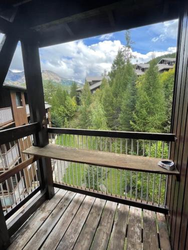 a balcony with a bench on a deck at Le Seignus d'Allos T2 30m2. Aux pieds des pistes. in Allos