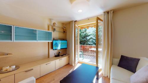 a living room with a couch and a television at Chesa Seraina Abitaziun Seraina 7 - Chamois in Madulain