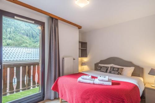 une chambre avec un lit et une grande fenêtre dans l'établissement Appartement du Midi - Welkeys, à Chamonix-Mont-Blanc