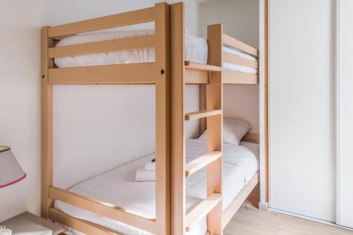 Cette chambre dispose de lits superposés avec 2 lits superposés et un miroir. dans l'établissement Appartement du Midi - Welkeys, à Chamonix-Mont-Blanc