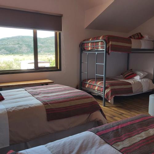 a bedroom with two bunk beds and a window at Morrena Lodge in Torres del Paine