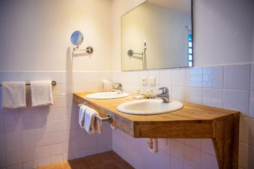 a bathroom with two sinks and a mirror at Quill Gardens Boutique Hotel in Oranjestad