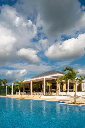a resort with palm trees and a swimming pool at Hotel Casa Hemingway in Juan Dolio