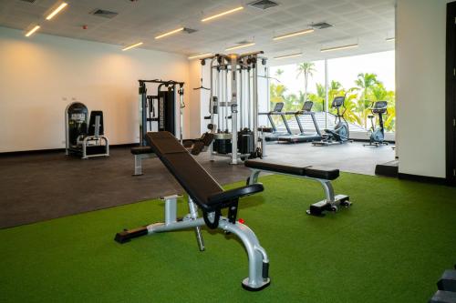 a gym with several tread machines and green carpet at Hotel Casa Hemingway in Juan Dolio