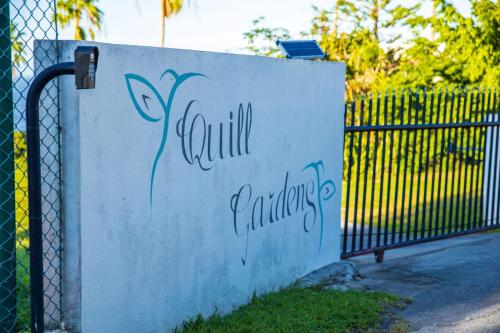 a fence with a sign that reads coil gardens at Quill Gardens Boutique Hotel in Oranjestad