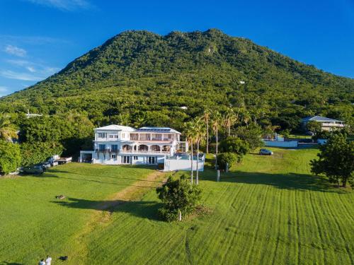 an aerial view of a large house in front of a mountain at Quill Gardens Boutique Hotel in Oranjestad