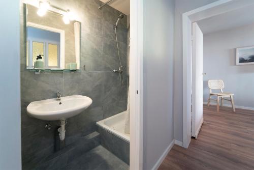 La salle de bains est pourvue d'un lavabo et d'une baignoire. dans l'établissement Strandkoje Wohnung 7, à Rettin