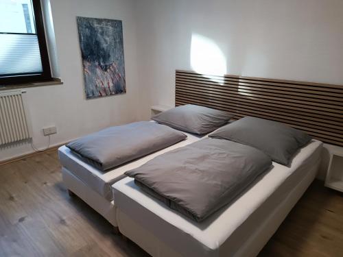 2 łóżka pojedyncze w sypialni z zagłówkiem w obiekcie Gruga Apartment an der Messe w Essen
