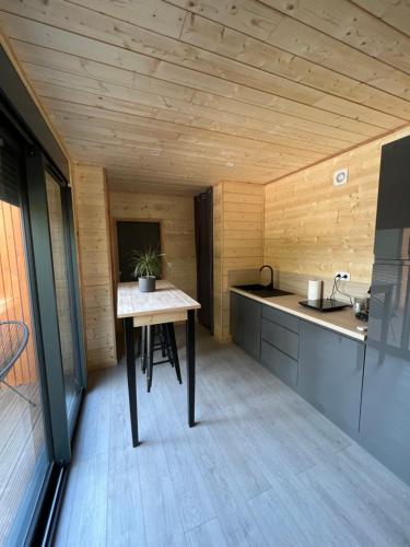 a small kitchen with a table in a room at Chalet 1 contemporain dans son écrin de verdure in Montauban