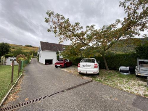 a house with two cars parked in the driveway at Maison familiale 152m2 à 10 minutes de Colmar in Wintzenheim