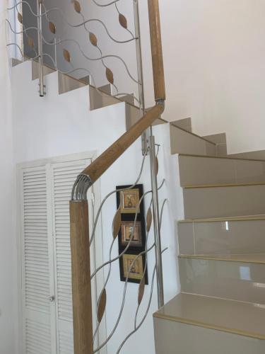 a spiral staircase with a metal rail and wooden railing at Casa Roa in Slănic