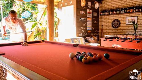 un homme faisant une partie de billard dans un bar dans l'établissement Pousada Sol & Sal Praia do Rosa, à Praia do Rosa