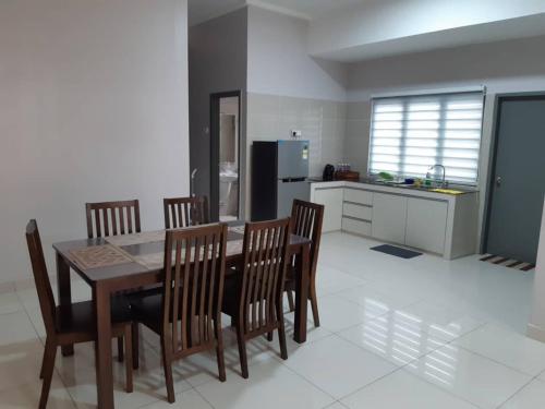 a kitchen with a dining room table and chairs at Labuan Paragon Apartment - 3 rooms in Labuan