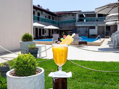 a drink sitting on a pole next to a pool at Pousada Villa Goyá in São José da Coroa Grande