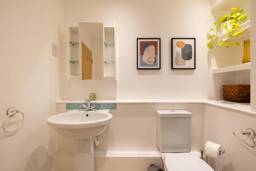 a white bathroom with a sink and a toilet at The Clapham Dream - Captivating 3BDR with Garden & Parking in London