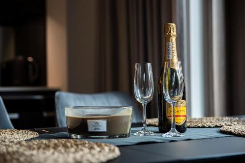 a bottle of champagne and two glasses on a table at SZKLARSKA VIEW Luxury Apartment Jacuzzi in Szklarska Poręba