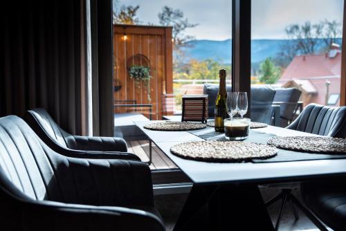 a table with a bottle of wine and a glass at SZKLARSKA VIEW Luxury Apartment Jacuzzi in Szklarska Poręba