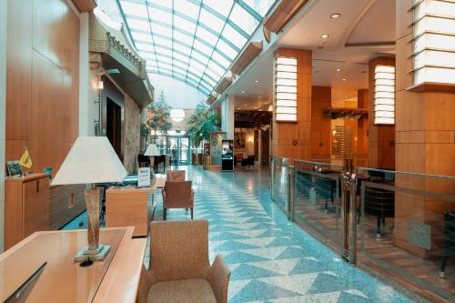 a lobby with a glass ceiling and a swimming pool at Holiday Inn Kuwait by IHG in Kuwait