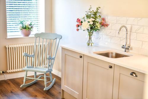 a kitchen with a chair next to a sink at Dovecote Farm House in Goole