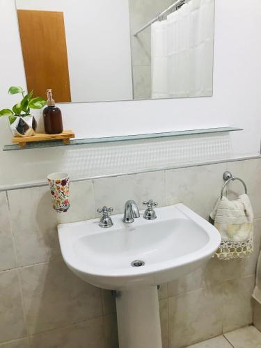 a white sink in a bathroom with a mirror at Departamento luminoso y céntrico in Santiago del Estero