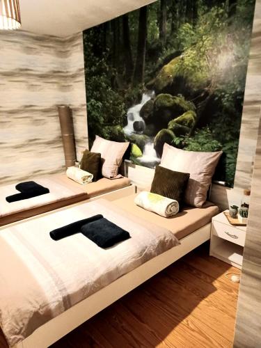 two beds in a room with a painting on the wall at Zur Linde in Mainzweiler