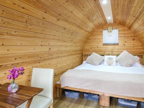 a bedroom with a bed in a wooden room at The Pod at Bank House Farm in Stafford