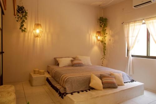 1 dormitorio con cama con almohadas y ventana en La Casa Bonita en Puerto Escondido
