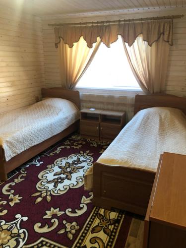 a bedroom with two beds and a window at Біля комори in Pilipets