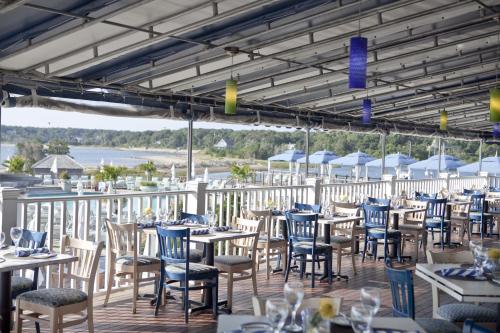 a restaurant with tables and chairs on a deck at Wequassett Resort and Golf Club in East Harwich