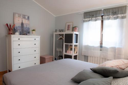 a bedroom with a bed and a dresser and a window at Alloggio Turistico di Giulia in Viterbo