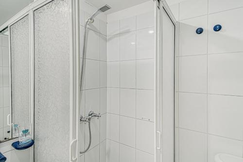 a white bathroom with a shower with a glass door at Bay Dream 2B W/Wifi, Grill & View. in San Antonio