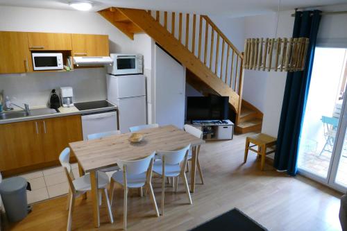cocina y comedor con mesa de madera y sillas en Appartement Duplex dans Résidence VAL DE ROLAND, en Luz-Saint-Sauveur