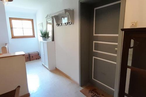 a kitchen with a refrigerator and a door in a room at Gemütliche Waldrandlage in Badenweiler Sehringen Ferienwohnung in Badenweiler