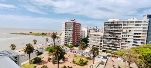 uma vista aérea da praia e dos edifícios em Rambla Apart em Montevidéu