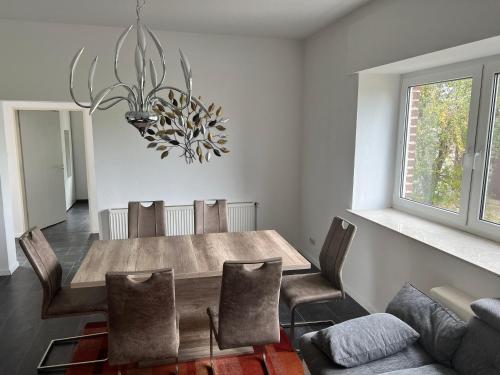 a dining room with a wooden table and chairs at Wiehengebirgs Fernblick App1 in Bad Essen
