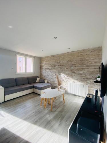 a living room with a couch and a table at Appartement - Roanne in Roanne