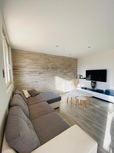 sala de estar con sofá grande y TV de pantalla plana en Appartement - Roanne en Roanne