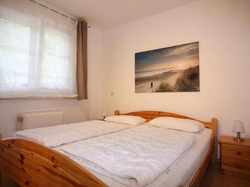 a bed in a bedroom with a picture on the wall at Ferienwohnung, Trassenheide in Trassenheide