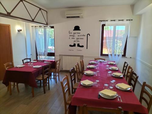 a dining room with tables and chairs with red tablecloths at Quattroventi in Montecchio