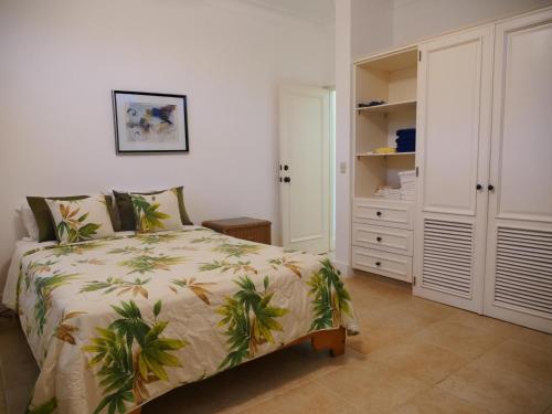 1 dormitorio con 1 cama con manta de palmera en The Victorian Luxury Condo E-2, en Cabarete