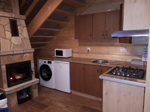 uma cozinha com um fogão e uma máquina de lavar e secar roupa em Domek w górach pod Jodłami em Nowy Targ