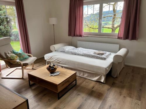 a bedroom with a bed and a table and a chair at Pferdehof Thomayer in Strasswalchen