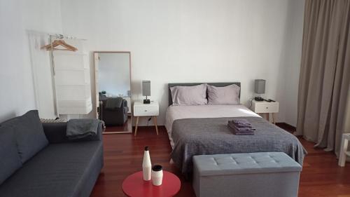 sala de estar con cama y sofá en Flores Central, en Oporto