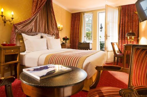 a hotel room with a bed and a table at Hôtel de Varenne in Paris